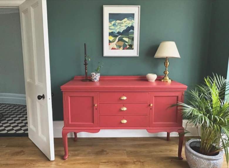 Teal wall with a raspberry painted sideboard